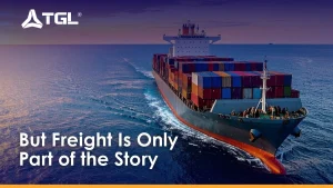 Large cargo ship fully loaded with colorful shipping containers sailing on the ocean during sunset.